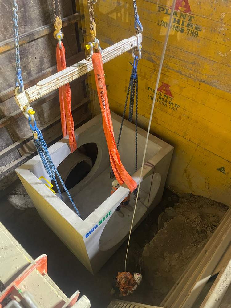 Precast pit lowered on a spreader bar with rated slings